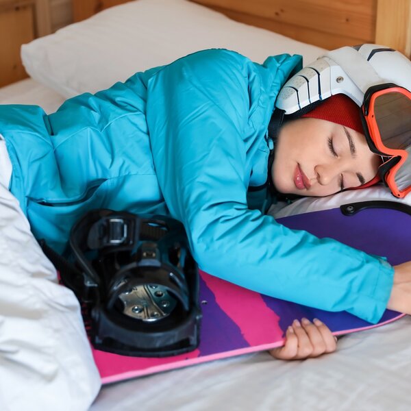 Ragazza che dorme abbracciando uno snowboard | © Archivio Immagini Val di Fassa